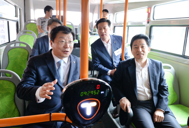 주형환 산업통상자원부 장관(왼쪽)과 원희룡 제주도지사가 21일 오전 에너지신산업 현장인 제주도 서귀포시 대륜동에서 배터리 교환형 전기버스에 탑승해 전기차 발전방안 등에 대해 대화하고 있다.  ［사진제공=산업통상자원부]