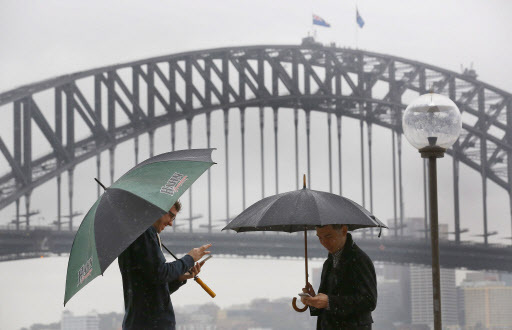 People play “Pokemon Go” near the Sydney Harbor Bridge in Sydney, Australia, on July 20. (EPA-Yonhap)