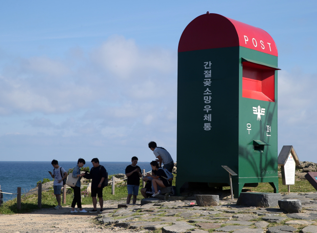 CATCHING POKEMON IN ULSAN — Citizens play Nintendo’s augmented-reality mobile game “Pokemon Go” in Ganjeolgot, a coastal park in the southeastern city of Ulsan in South Korea on Friday. The internationally-popular game became partially operational in area from Friday, as the game officially began service in nearby Japan the same day. Pokemon Go has yet to officially launch in Korea, though the game works in certain cities such as Sokcho and Ulsan as the game’s GPS signal is active there. (Yonhap)