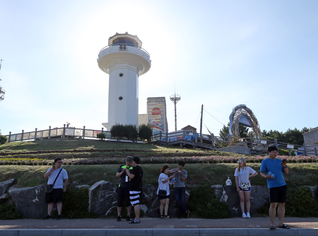 CATCHING POKEMON IN ULSAN — Citizens play Nintendo’s augmented-reality mobile game “Pokemon Go” in Ganjeolgot, a coastal park in the southeastern city of Ulsan in South Korea on Friday. The internationally-popular game became partially operational in area from Friday, as the game officially began service in nearby Japan the same day. Pokemon Go has yet to officially launch in Korea, though the game works in certain cities such as Sokcho and Ulsan as the game’s GPS signal is active there. (Yonhap)