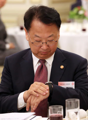 유일호 경제부총리가 지난 22일 청와대에서 열린 중견기업인 격려오찬에서 시계를 보고 있다.