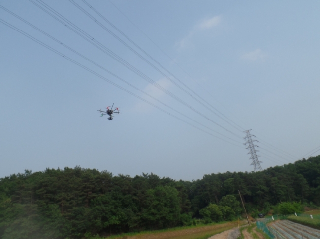 한전 직원들이 드론으로 고공 전력설비를 점검하고 있다.[사진제공=한전]