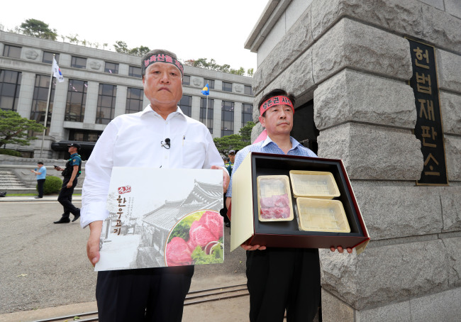 Members of an association of farmers hold a protest in front of the Constitutional Court against its decision to uphold the disputed antigraft law on Thursday. (Yonhap)