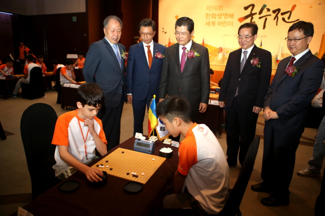 한화생명 차남규 대표(왼쪽에서 세번째), 유창혁 9단(맨 오른쪽) 등이 루마니아 어린이와 한국 어린이 기사의 대국을 지켜보고 있다. 아래 사진은 한화생명 윤병철 부사장과 우승자 한우진군(오른쪽)