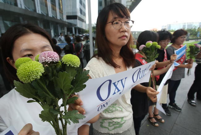 The families of victims of the toxic humidifier disinfectants hold a protest Wednesday in front of the Oxy Reckitt Benckiser's headquarters in Seoul. (Yonhap)