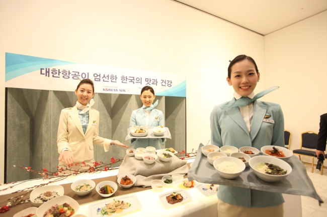 Korean Air flight attendants pose with in-flight Korean cuisine meals. Korean Air