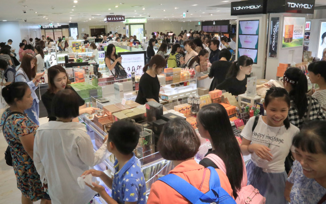 Tourists shop at a duty-free store in Seoul (Yonhap)