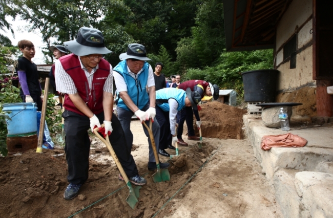 이상무 농어촌공사 사장(왼쪽에서 두번째)이 폭염에도 불구하고 소속 직원들, 대학생 봉사단과 함께 농어촌 집 고쳐주기 봉사활동을 펼치고 있다. [사진=한국농어촌공사]