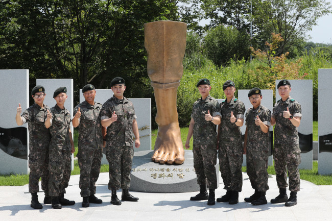 4일 북한 비무장지대(DMZ) 지뢰도발 1주기 기념행사에서 육군 1사단 DMZ 수색대 전우 8인이 ‘평화의 발’ 조형물 앞에서 천하제일 구호를 외치고 있다. 왼쪽부터 박준호 예비역 병장, 이형민 하사, 박선일 원사, 하재헌 하사, 김정원 하사, 정교성 중사, 최유성 예비역 병장, 문시준 중위.