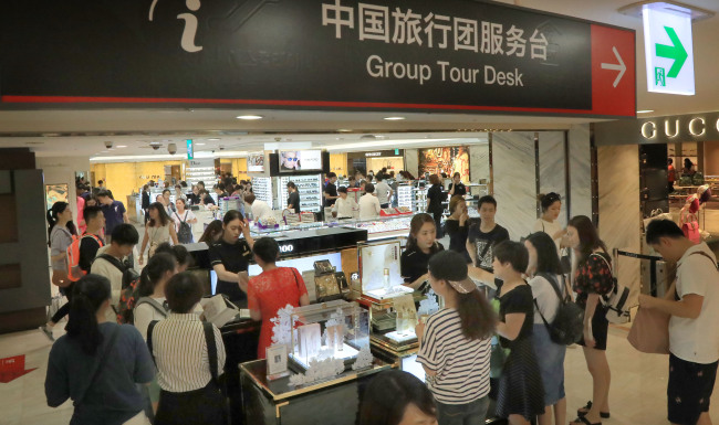 This Aug. 1 photo shows Chinese tourists purchasing Korean cosmetics products at Lotte Duty Free Store in Myeongdong, central Seoul. (Yonhap)