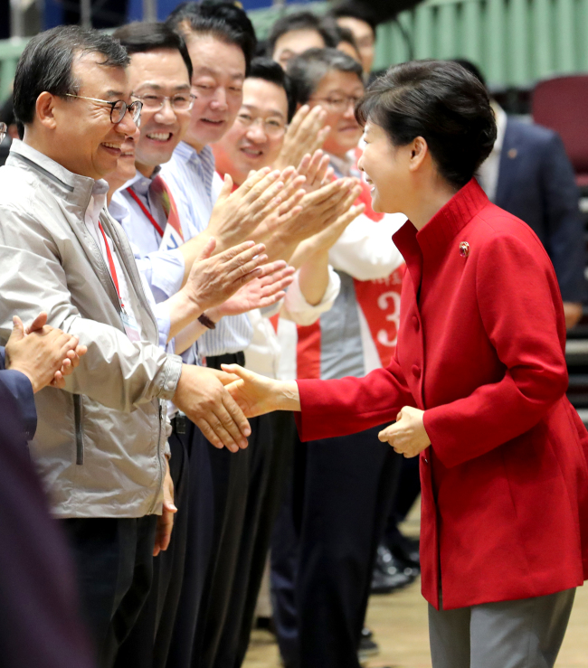 President Park Geun-hye reaches out to shake hands with Rep. Lee Jung-hyun, who later won the chairmanship at the party’s convention in Jamsil, Seoul, Tuesday. (Yonhap)