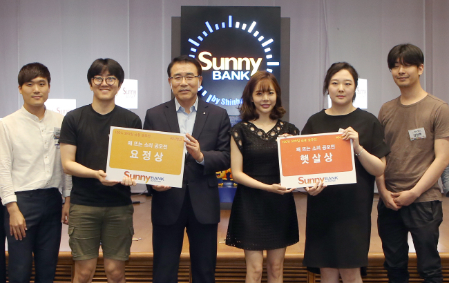 조용병 신한은행 은행장(왼쪽 세 번째)이 최근 서울 중구 태평로 소재 신한은행 본점 대강당에서 열린 ‘써니뱅크 해뜨는 소리 시상식’에서 소녀시대 써니(네 번째)와 함께 수상자들과 기념 촬영하고 있다.  [사진=신한은행 제공]