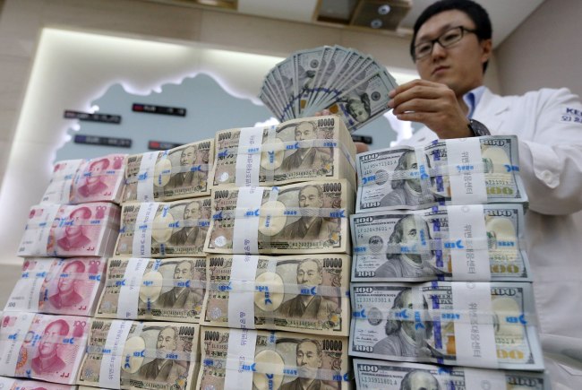 An employee of Korea Exchange Bank counts US dollars at the lender's main office in Seoul.