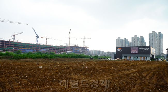불볕더위를 식히는 소나기에도 고양삼송복합쇼핑센터 공사는 계속됐다. 이곳은 내년 ‘신세계 스타필드 고양점’으로 간판을 내걸고, 글로벌 가구 공룡 ‘이케아’와 수도권 서북부 유통의 지각변동을 일으킬 것으로 기대된다. 사진은 엠디엠그룹이 하반기 분양하는 ‘e편한세상 시티 삼송 2차’ 사업지에서 바라본 쇼핑센터 공사현장.
