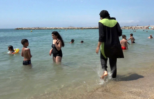In this Aug. 4 2016 file photo made from video, Nissrine Samali, 20, gets into the sea wearing a burkini, a wetsuit-like garment that also covers the head, in Marseille, southern France, on Aug. 4. (AP-Yonhap)
