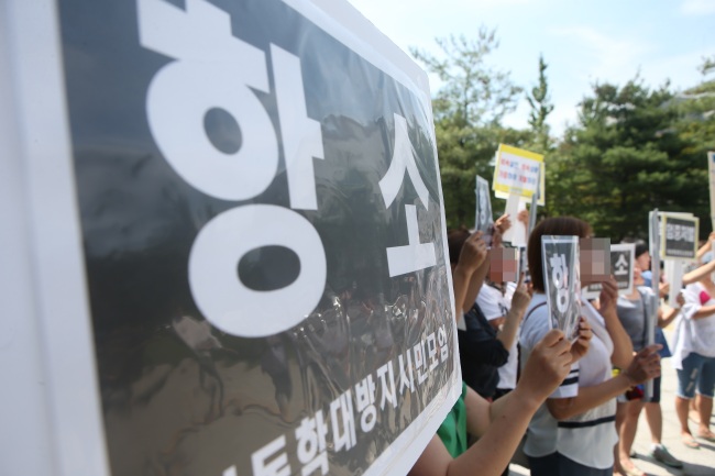 Members of an anti-child abuse organization stage a protest on Aug. 10, calling for strict punishment on parents of Shin Won-young, a seven-year-old who died in February after being severely abused and neglected by his father and stepmother. The stepmother was sentenced to 20 years in jail, while the child’s father was sentenced to 15 years behind bars. (Yonhap)
