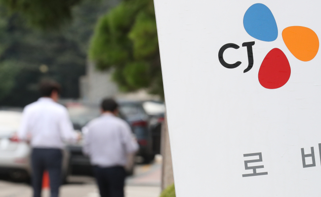 CJ Group employees walk alongside the group’s headquarters in Seoul.