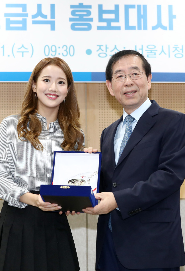 April’s Naeun (left) receives a trophy from Seoul Mayor Park Won-soon at Seoul City Hall on Wednesday. (Yonhap)