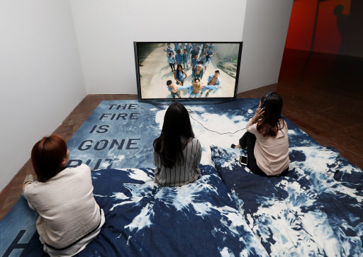Visitors view “Painting With History in a Room Filled With People With Funny Names 3” by Korakrit Arunanondchai at Seoul Museum of Art on Wednesday. (Yonhap)
