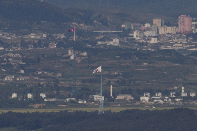 The image taken on Aug. 29 from Paju, Gyeonggi Province, shows towns near the inter-Korean border where the South and North Korean flags respectively flap. (Yonhap)