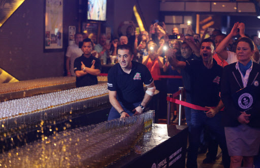 Ahmad Taher, food and beverage manager for Citymax Hotels in Dubai, United Arab Emirates, pushes over a shot glass in a successful attempt at the world‘s longest domino drop shot on Monday. (AP-Yonhap)