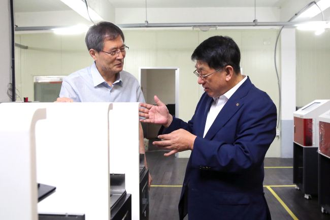 임채운 중진공 이사장(오른쪽)과 이병극 ㈜캐리마 대표가 제품에 대해 이야기를 나누고 있다. [사진 제공=중진공]