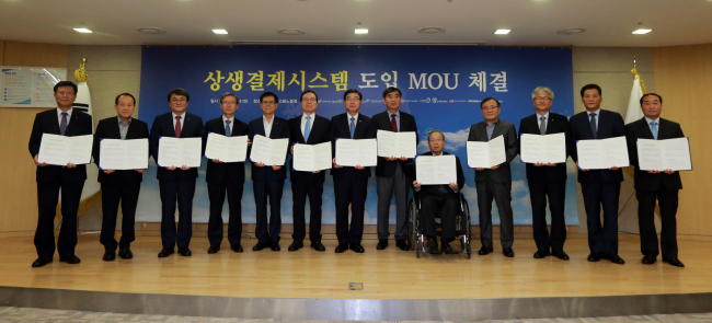안충영 동반성장위원장(가운데)과 이기권 고용노동부 장관을 비롯한 고용부 산하기관장들이 업무협약을 체결한 뒤 기념촬영을 하고 있다. [사진 제공=동반성장위원회]