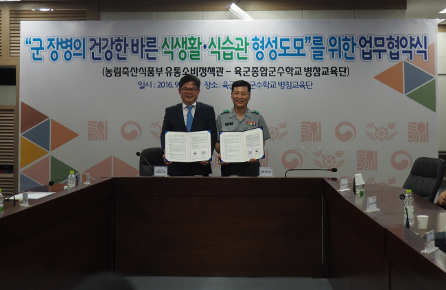 허태웅(왼쪽) 농림축산식품부 유통소비정책관이 6일 국방부 육군종합군수학교 병참교육단과 식생활 교육 등을 강화하는 내용을 담은 업무협약을 체결한 후 기념촬영하고 있다.  ［사진제공=농림축산식품부］