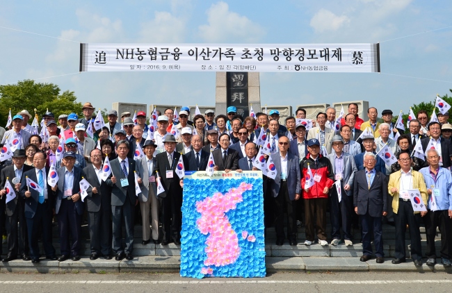 NH농협금융지주 김용환 회장(앞줄 오른쪽부터 8번째)이 이산가족과 함께 직접 만든 한반도 모양의 무궁화 꽃 조형물을 배경으로 기념촬영을 하고 있다.
사진=NH농협금융 제공