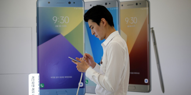 A sales person uses a Galaxy Note 7 smartphone at a Samsung Electronic retail shop in Seoul.