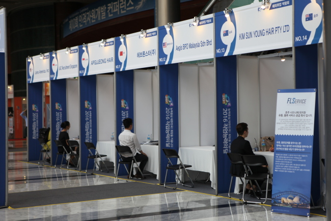 Job seekers speak with recruitment representatives at the K-Move Overseas job fair in Seoul. The Korea Herald