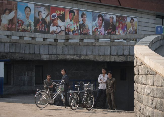 Men stand next to cycles beneath film posters at the Pyongyang International Cinema during the 15th Pyongyang Film Festival in the capital of North Korea on September 23, 2016. (Yonhap-AFP)