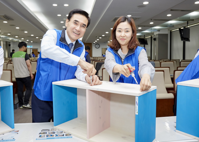 안민수(왼쪽) 삼성화재 사장이 점심시간을 활용해 결연아동에게 전달할 책장을 만들고 있다.