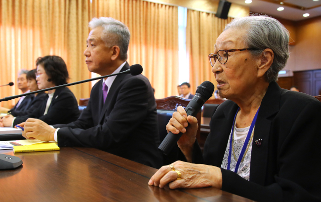 Kim Bok-dong (right), a victim of Japan's sex slavery during World War II, speaks during a parliamentary audit at the Foreign Ministry on Monday, which was attended by Lee Sang-deok (second from right), Seoul's ambassador to Singapore who had led negotiations with Japan on the issue as director-general for Northeast Asian affairs. (Yonhap)