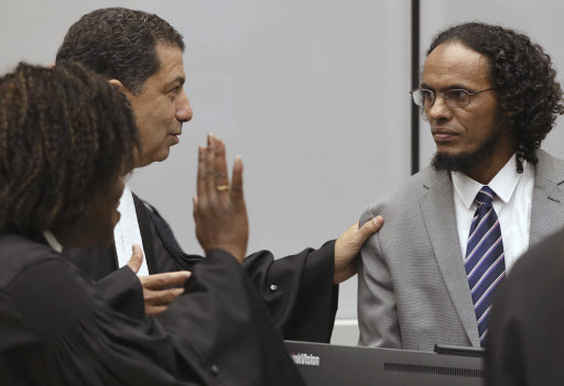 Ahmad Al Faqi Al Mahdi (right) a Malian Islamic extremist who pleaded guilty to the destruction of historic mausoleums in Timbuktu, listens to his defense team as he enters the court room to hear the verdict of the International Criminal Court in The Hague, Netherlands, Tuesday. (AP-Yonhap)