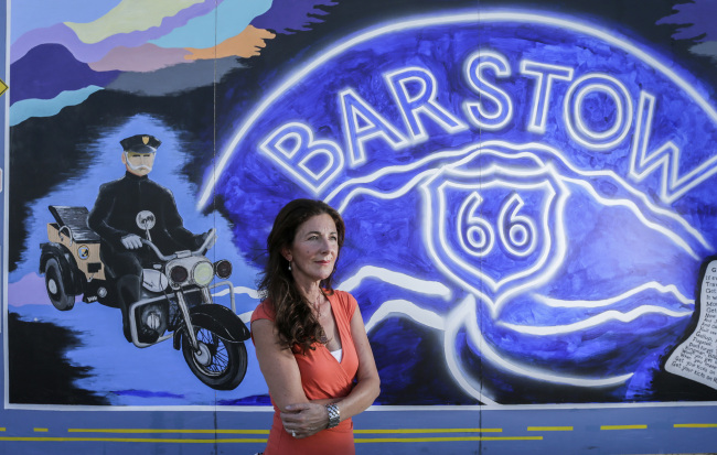 Jane Laraman-Brockhut, former president of Main Street Murals and current director of Desert Discovery Center, stands near a mural adjacent to Route 66. The murals commemorate California and Barstow history. (Los Angeles Times/TNS)