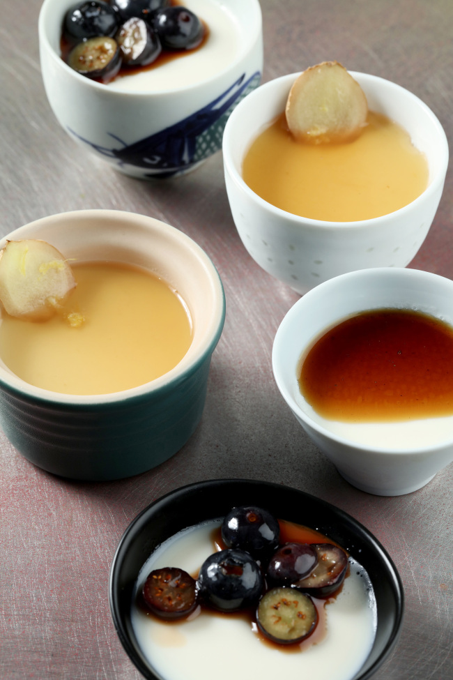 Japanese milk pudding with black sugar sauce, ginger-lemon sauce and macerated blueberries. (Chicago Tribune/TNS)
