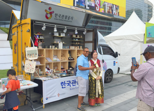 ▶찾아가는 관광기념품 트럭앞에서 외국인 관광객이 기념촬영을 하고 있다.