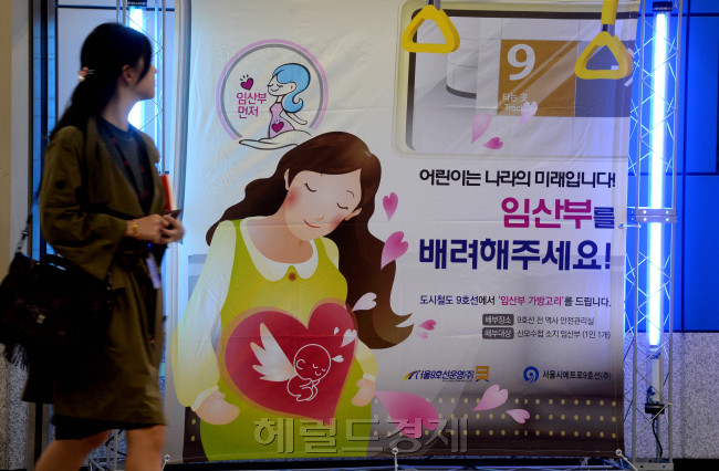 서울 지하철 9호선에서 ‘임산부를 배려하자’는 캠페인성 홍보물 앞으로 시민이 걸어가고 있다.   박현구 기자/phko@