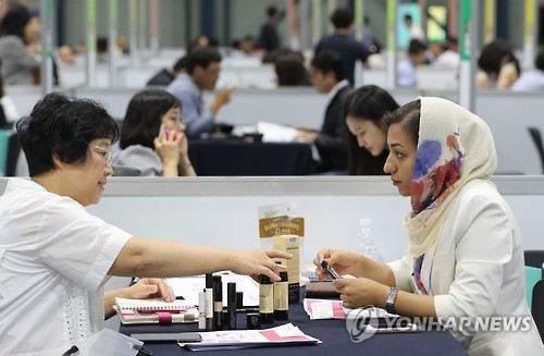 A participant receives a business consultation during a cosmetics exhibition held in Seoul. (Yonhap)