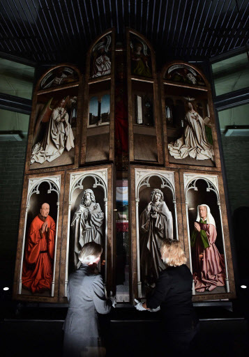 This file photo taken on Oct. 12 shows officials unveiling the restored exterior panels of “The Adoration of the Mystic Lamb,” an altar piece painted by the Van Eyck brothers in 1432, at Saint Bavo Cathedral in Ghent, Belgium. (Emmanuel Dunand/AFP-Yonhap)