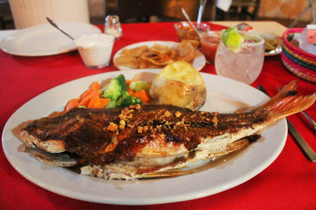 A Mexican coastal classic -- huachinango al mojo de ajo (garlicky whole red snapper) -- is done right at venerable Beto‘s Restaurant on Playa Condesa. (Chicago Tribune/TNS)
