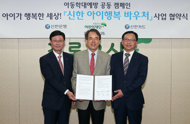 지난 26일   ‘아이가 행복한 세상, 신한 아이행복바우처’ 사업 협약식을 마치고 신한은행 유동욱 부행장(왼쪽)과 신한카드 손기용 부사장(오른쪽), 초록우산 어린이재단 이제훈 회장이 기념촬영하고 있다