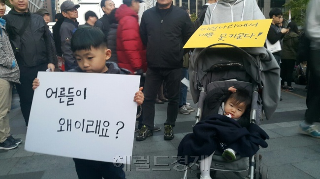 29일 서울 청계광장에서 열린 촛불집회에는 남녀노소를 불문하고 수많은 시민들이 모여들었다.  부모님을 따라 촛불집회에 참가한 6세 남아가 피켓을 들고 있다. 신동윤 기자/realbighead@