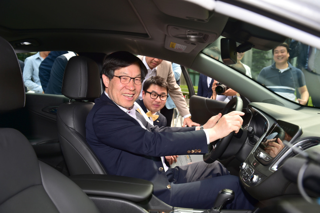 권오준 포스코 회장이 지난 5월 23일 포스코센터 정문에서 열린 한국GM ‘올 뉴 말리부’ 프로모션 현장에서 올 뉴 말리부 내외부를 자세히 살펴본 후 운전석에 앉아 포즈를 취하고 있다.  [사진제공=포스코]