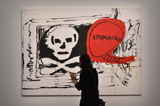 A woman visits the exhibition “Jean-Michel Basquiat,” a retrospective on Jean-Michel Basquiat’s career from graffiti in New York to more complex work, at the Mudec Museum in Milan on Thursday. (AFP-Yonhap)