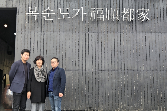 Family owners of Boksoondoga rice wine winery Kim Min-kyu, Park Bok-soon and Kim Min-kook pose in front of the brewery headquarters in Ulsan. (Julie Jackson/The Korea Herald)