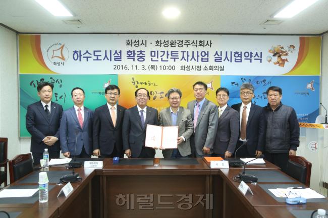 [사진=최광호 한화건설 대표이사(좌부터 네번째), 채인석 화성시장(좌부터 다섯번째) 등이 화성시 하수도시설 확충 민간투자사업 실시협약을 체결하고 기념촬영을 하고 있다.]