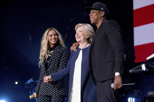 US Democratic presidential candidate Hillary Clinton (center) embraces US singer Beyonce (left) and her husband and rapper Jay-Z during the "Get Out The Vote" concert at the Wolstein Center in Cleveland, Ohio on Nov. 4. (Yonhap)
