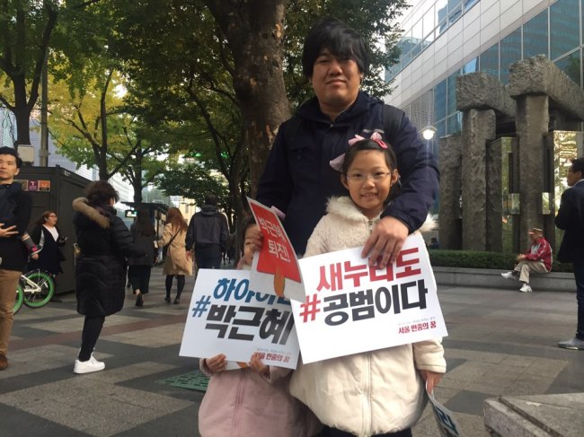 민중총궐기 투쟁본부 등 진보 진영 시민사회ㆍ노동단체들은 4일 오후 서울 종로구 광화문광장에서 ‘모이자! 분노하자! #내려와라 박근혜 2차 범국민행동’ 문화제가 광화문 광장에서 개최했다. 이날 집회에는 경찰 추산 4만3000여 명(주최 측 추산 10만여 명)이 모였다. 아버지와 딸 둘이 집회에 참가한 모습. 김진원 기자/jin1@heraldcorp.com